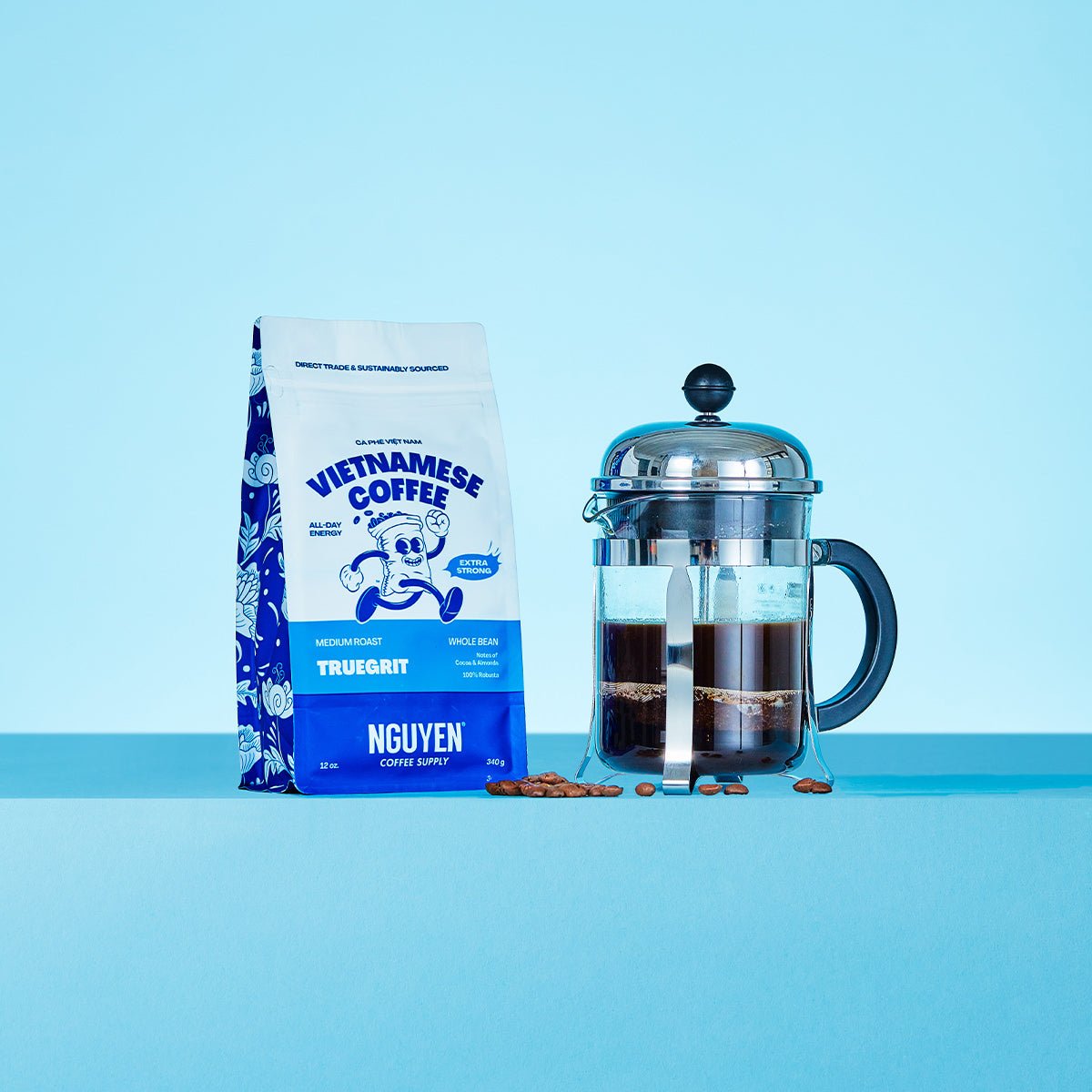 A bag of Nguyen Vietnamese coffee Truegrit medium roast extra strong next to a french press filled with brewed coffee